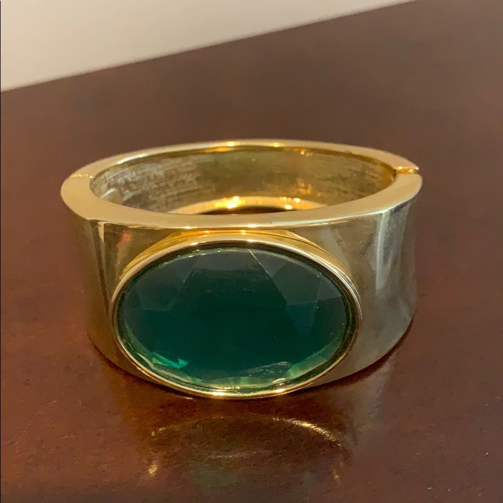 Gold colored bangle bracelet with green accent